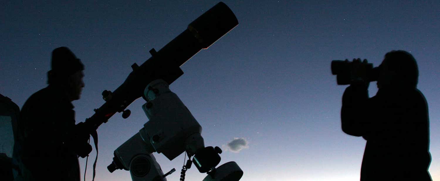 To the left is a man observing the night sky with a telescope. To the right is a man using binoculars.