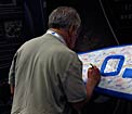 Attendee signing the IAU surfboard